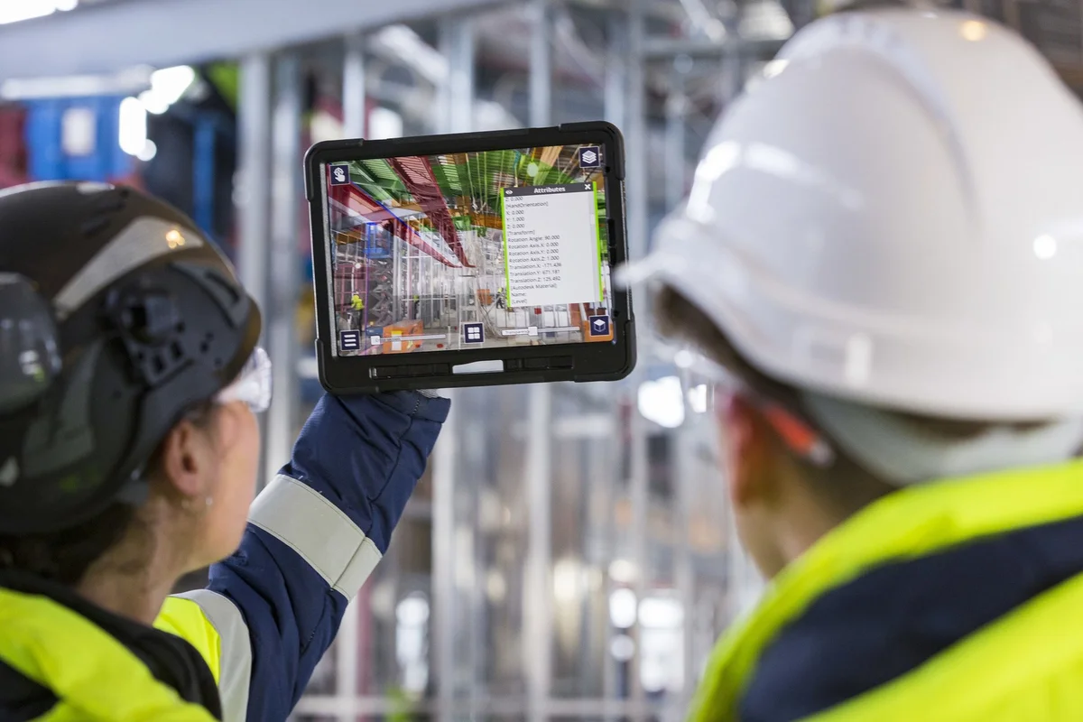 Workers reviewing a building model on a tablet